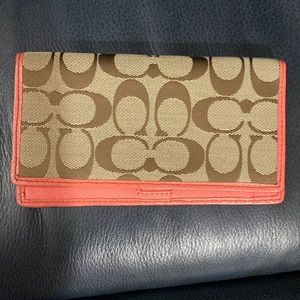 Brown and tan coach check book cover with coral trim